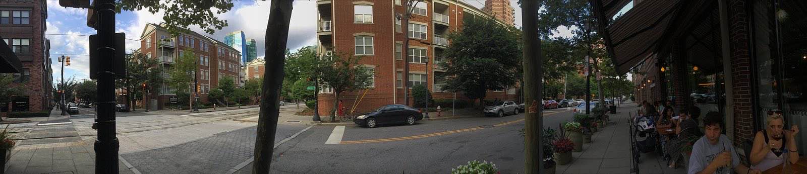 A typical block on Warren Street, with restaurants stores and brownstones. Skyscrapers in background.